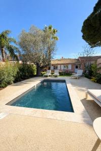 a swimming pool with two chairs and a house at Villa Clemarine - Piscine & Jacuzzi in Sanary-sur-Mer