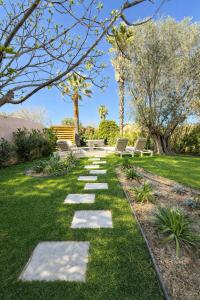 a walkway in a yard with benches and trees at Villa Clemarine - Piscine & Jacuzzi in Sanary-sur-Mer +24 photos