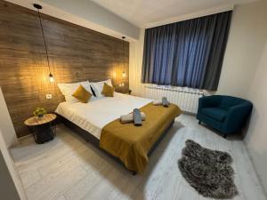 a hotel room with a bed and a blue chair at Guest houses Forte in Tsigov Chark