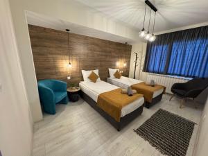 a hotel room with two beds and a blue chair at Guest houses Forte in Tsigov Chark +7 photos
