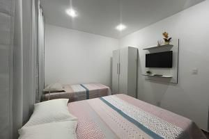 a bedroom with a bed and a tv on the wall at Studio Caju in Mossoró