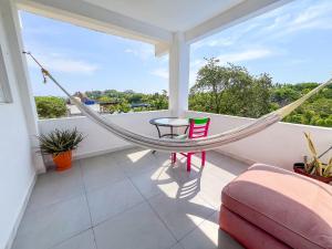 a hammock on the balcony of a house at Valentina Salchi Bay virgin beaches fast internet in Cuatunalco