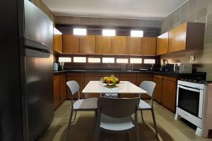 a kitchen with a table and chairs and a refrigerator at Studio Sol in Mossoró