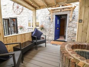 a patio with a blue door and chairs on a deck at The Ranch in Prestatyn