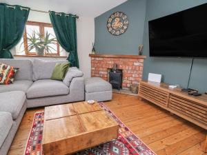 a living room with a couch and a flat screen tv at The Ranch in Prestatyn