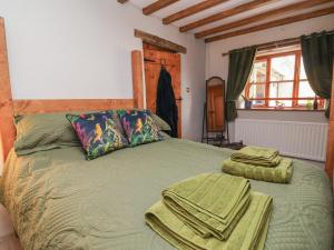 a bedroom with a green bed with towels on it at The Ranch in Prestatyn