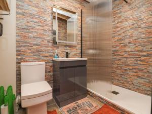 a bathroom with a white toilet and a brick wall at The Ranch in Prestatyn +39 photos