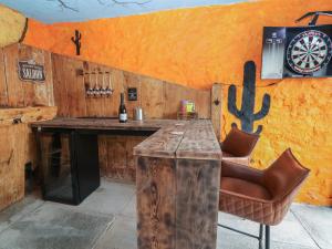 a bar with a table and a dartboard on a wall at The Ranch in Prestatyn