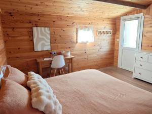 a bedroom with wooden walls and a bed and a desk at Le Chalet des Pins - La Forge De Clermont in Clermont +11 photos
