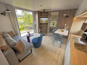 a living room with a couch and a table at Feriendorf Seeblick - Tiny Chalet Nr 8 in Neunburg vorm Wald