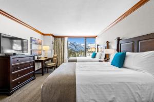 a hotel room with two beds and a desk and a television at Olympic Valley Summer Stay: Everline Resort & Spa! in Olympic Valley +33 photos