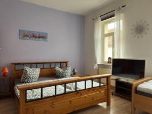 a bedroom with a wooden bed and a television at Ferienwohnung in Ballenstedt in Ballenstedt +25 photos