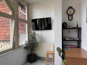 a living room with a tv and a table and a window at Ferienwohnung in Ballenstedt in Ballenstedt
