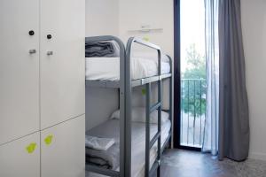 a bunk bed in a room with a window at Meeting Point Hostels in Barcelona