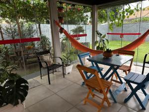 a porch with a hammock and a table and chairs at Pousada Luar in Chapada dos Guimarães