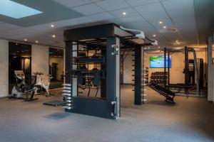 a gym with treadmills and machines in a room at Holiday Inn Hotel Brussels Airport by IHG in Diegem