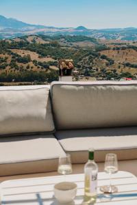 a table with two glasses and wine bottles on it at Beautiful villa with private pool and mountain views in Jimena de la Frontera +35 photos