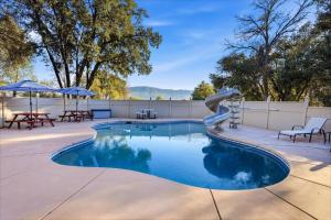 a swimming pool with a slide in a backyard at Splash Mountain in Oakhurst
