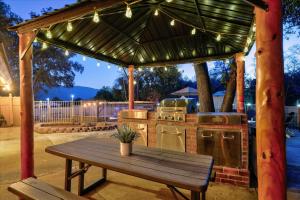 an outdoor kitchen with a wooden table and a wooden bench at Splash Mountain in Oakhurst +48 photos