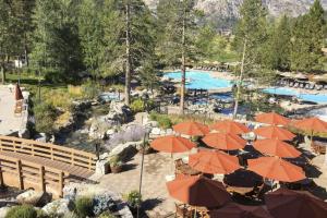 a resort with orange umbrellas and a swimming pool at Resort Perks! Everline Corner Retreat w/ 3 Units in Olympic Valley