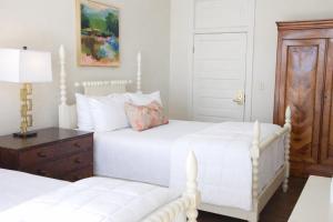 a bedroom with two white beds and a dresser at The St Nicholas Hotel in Albany