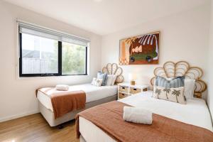 a bedroom with two beds and a window at Super-Styled Light-Filled Eco Home in Torquay