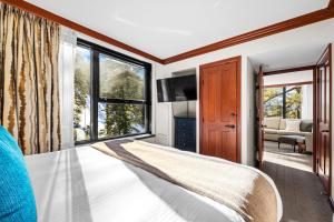 a bedroom with a bed and a large window at Pool, Hot Tub & Golf: Everline Resort Corner Suite in Olympic Valley +37 photos