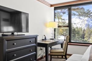 a bedroom with a desk and a bed and a window at Valley-View Unit in Everline Resort: Premier Perks in Olympic Valley