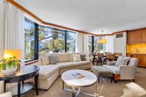 a living room with a couch and tables and windows at High Sierra Summer Stay in Everline Resort & Spa! in Olympic Valley