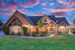 a house with a landscaping in front of it at Mountain Elegance w/ pool, spa, projector in Coarsegold