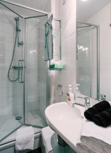 a bathroom with a sink and a glass shower at Tripel B in Bruges