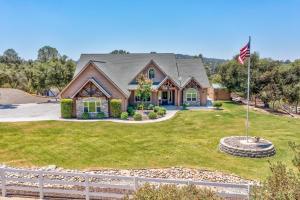 a house with an american flag in front of it at Mountain Elegance w/ pool, spa, projector in Coarsegold +55 photos