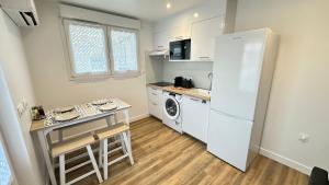 a small kitchen with a refrigerator and a table at Les Jonquilles in Vernon