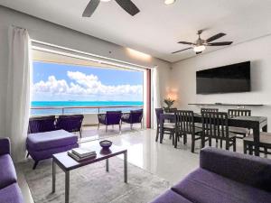 a living room with a view of the ocean at Isla Condo Puerta al Mar 403 at Sac Bajo in Isla Mujeres