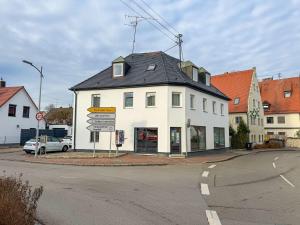 a white building on the corner of a street at My Pension City Stadtbergen Augsburg in Stadtbergen