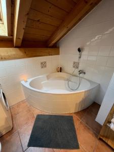 a large bath tub in a bathroom with a ceiling at Heidis Ferienwohnung Abendlicht in Egling