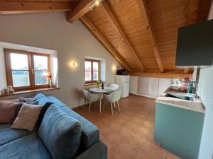 a living room with a blue couch and a kitchen at Heidis Ferienwohnung Abendlicht in Egling +9 photos