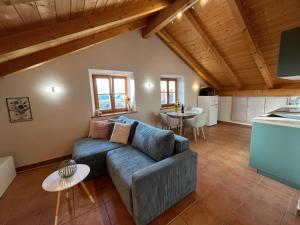 a living room with a couch and a table at Heidis Ferienwohnung Abendlicht in Egling