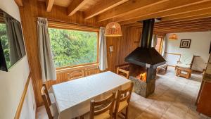a dining room with a table and a fireplace at Apart Hotel del Pellin in San Martín de los Andes