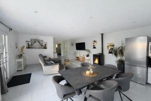 a kitchen and living room with a table and chairs at Maison avec piscine in Golbey