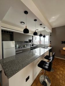 a kitchen with a large island with a counter top at Espacio San Martin - Departamento en plena peatonal con Seguridad 24 hs in Santa Fe