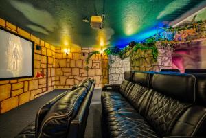 a room with leather seats in a room with a stone wall at Windsor Resort Private Pool & Theater Game Room in Davenport