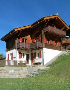 a house with a balcony on top of a hill at Chalet Safran in Grächen