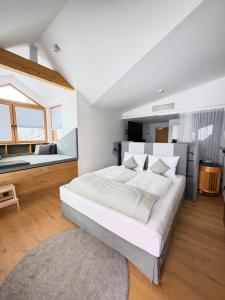 a bedroom with a large white bed and a large window at Berghotel Predigstuhl in Bad Goisern +32 photos
