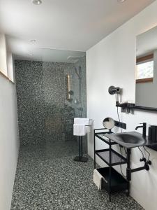 a bathroom with a shower with a black chair at Berghotel Predigstuhl in Bad Goisern