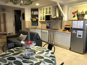 a kitchen and a table in a kitchen with a table and a tableablish at Côté Baie avec parking-wifi- draps et serviettes in Hendaye