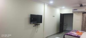 a room with a flat screen tv on the wall at HoTEL SRI DURGA GRAND in Vijayawāda