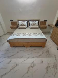 a bed in a room with a marble floor at Da Sampurn Hotel in Tiuni +3 photos