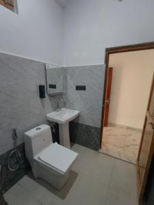 a bathroom with a toilet and a sink at Da Sampurn Hotel in Tiuni
