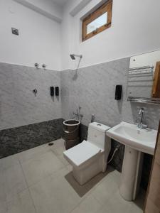 a bathroom with a toilet and a sink at Da Sampurn Hotel in Tiuni